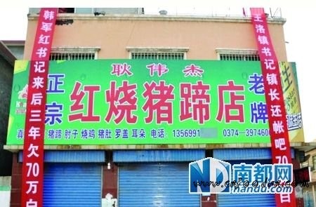 耿伟杰在自家的猪蹄店外挂上“讨账”横幅。 网络图片